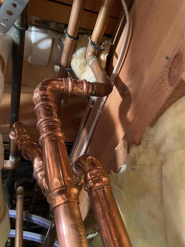 Responded to callback for persistent leaks following previous boiler repipe work. Identified and addressed three leak points: drain valve, 1.25" copper 90-degree elbow, and 3/4" copper 90-degree elbow. Cut out defective fittings and installed new copper fittings with proper soldering techniques to ensure watertight connections and system integrity.