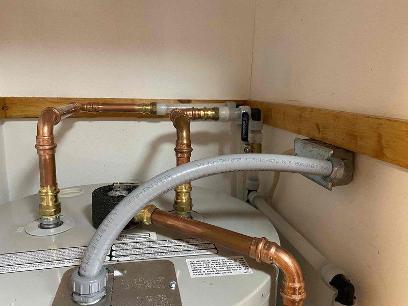 Installed a new Bradford White 50-gallon electric water heater, model RE250T6-1NCWW, rated at 240V with dual 4500W heating elements and 150 psi working pressure. Performed water line alterations including copper pipe reconfiguration with brass fittings and proper pressure relief valve assembly. Replaced the right basket strainer assembly in the kitchen sink to restore proper drainage function.