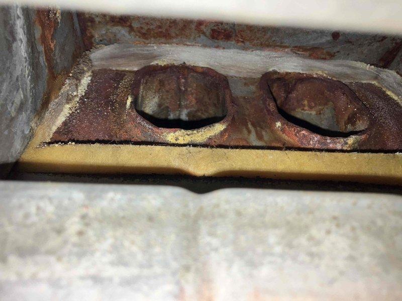 Responded to no heat call on 15-20 year old natural gas furnace. Found burner box damper door unable to close properly, preventing safety switch engagement and system startup. Inspection revealed heavily corroded burner compartment components and failed door spring mechanism. Replaced door spring and associated mounting hardware to restore proper damper operation and safety switch function. Due to extensive corrosion throughout burner assembly and age of unit, recommended full system replacement for both furnace and air conditioning equipment. Unit restored to temporary operation pending replacement.