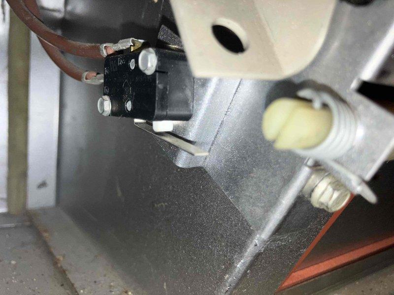 Responded to no heat call on 15-20 year old natural gas furnace. Found burner box damper door unable to close properly, preventing safety switch engagement and system startup. Inspection revealed heavily corroded burner compartment components and failed door spring mechanism. Replaced door spring and associated mounting hardware to restore proper damper operation and safety switch function. Due to extensive corrosion throughout burner assembly and age of unit, recommended full system replacement for both furnace and air conditioning equipment. Unit restored to temporary operation pending replacement.
