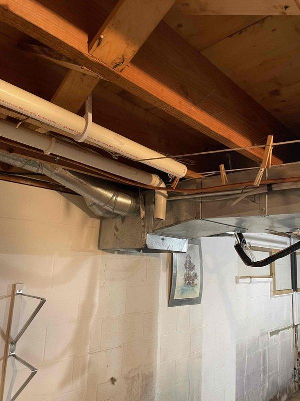 Completed first phase of HVAC system removal in preparation for replacement installation. Disconnected gas supply, electrical connections, and existing furnace from ductwork system. Removed return air cabinet and associated ductwork sections as needed for new equipment installation. Disconnected evaporator coil and refrigerant line set, properly recovering refrigerant into compressor unit per EPA regulations. Disconnected electric water heater from power supply and drained unit completely. Disconnected utility sink from plumbing connections. Documented existing water damage conditions observed on basement floor and foundation walls during demolition phase. Provided replacement recommendations for aging water heater unit to address potential future failure concerns.