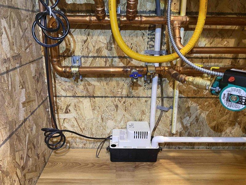 Performed comprehensive boiler and indirect water heater system repairs to bring installation into code compliance and improve serviceability. Added 3/4" black iron drip leg with union to boiler gas line, shortened flexible gas connector and relocated shutoff valve for proper configuration. Removed non-compliant PVC temperature and pressure relief discharge piping from both boiler and indirect water heater, replaced with code-compliant materials. Installed 1" thermostatic mixing valve on domestic hot water system with isolation valves on cold inlet and hot outlet, reconfigured recirculation line to circulate tempered water instead of drawing directly from indirect tank. Removed leaking 1" connection at boiler base and installed isolation valves with drain ports to allow future servicing without full system drain. Replaced corroded air vent on air separator. Added Fernox Protector F1 corrosion inhibitor to heating system. Refilled boiler, purged all air from system, tested heating and d