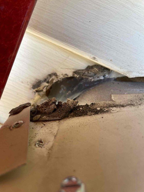 Responded to urgent callback regarding wildlife intrusion through recently installed mini split system penetration. Upon arrival, confirmed bats were entering residence through inadequate sealing around refrigerant line set and condensate drain penetration at rear exterior wall. Pest control had previously identified the mini split piping entry point as the access location. Inspected penetration and found existing sealant had failed, leaving gaps sufficient for wildlife entry. Applied additional clear silicone sealant over existing material to fully seal all openings around copper line set and drain piping where they enter the structure. Verified complete coverage of all gaps and voids at wall penetration point. Documented conditions with photographs showing before and after sealing work. System remains operational with no impact to refrigerant lines or drainage function.
