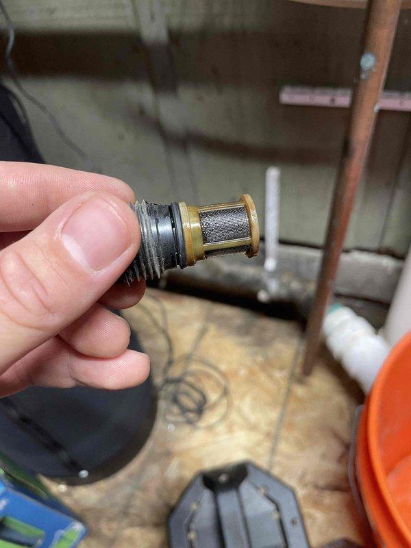 Completed annual prepaid plumbing inspection on tankless water heater system. During inspection, identified corrosion developing on secondary heat exchanger components, documented condition with photographs of affected parts including filter assembly and internal exchanger elements. Customer was informed of findings and current equipment condition for future maintenance planning.