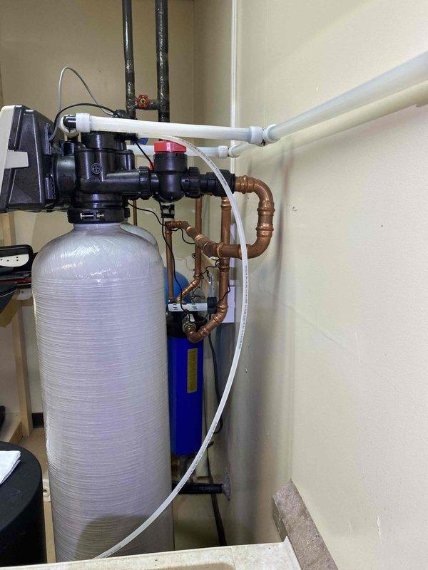 Installed Water Right IMPS-1054 Air Sulfur Filter with activated carbon to address persistent rotten egg odor in household water supply. The existing 10" carbon block filter cartridge was insufficient to eliminate the sulfur smell, necessitating an upgraded treatment system. The new air sulfur filter utilizes an air chamber within the tank to remove sulfur odor and improve iron removal that may bypass the existing water softener, providing superior performance compared to standard carbon cartridge systems.

Completed all necessary plumbing modifications in copper pipe to integrate the unit into the existing water system. Configured the self-cleaning discharge line and piped it to the 1.5" PVC standpipe located adjacent to the utility sink in the basement. Installed bypass piping with shutoff valves to allow for future maintenance and servicing. Mounted the control valve head on top of the filtration tank and completed all electrical connections required for automatic operation.

Tested