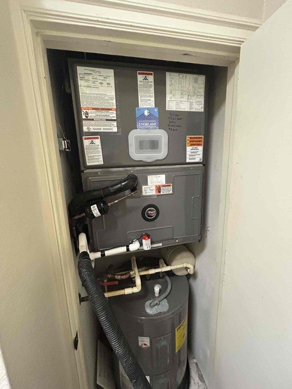 Completed second quarterly preventive maintenance inspection on residential HVAC system as part of routine maintenance agreement. Inspected electrical contactor with multi-wire connections, verified proper termination of all conductors and switching mechanism operation. Documented vertically-stacked utility closet configuration including air handler, water heater, and associated controls with photographic records for maintenance history.
