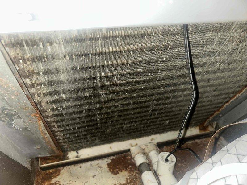 Fort Myers, FL - Responded to no cooling call where unit had frozen and been allowed to thaw for three hours but failed to restart. Upon inspection, found evaporator coil heavily contaminated with dust and debris accumulation restricting airflow, with visible rust staining on drain pan indicating moisture issues. Identified dirty coil as primary cause of freeze-up condition. System required thorough coil cleaning and airflow restoration to resolve cooling failure and prevent future freeze-ups.