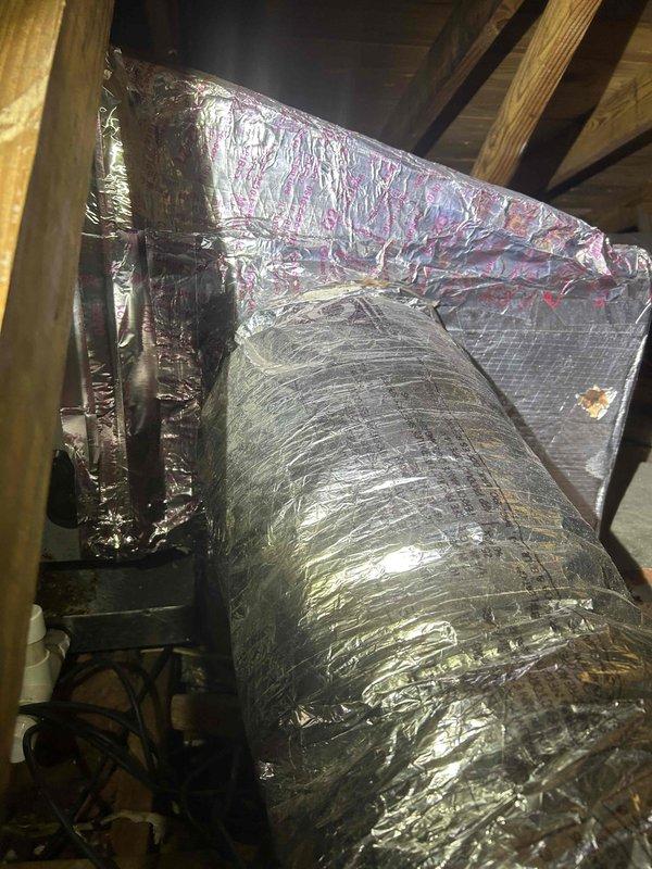 Fort Myers, FL - # HVAC Maintenance Inspection

Completed comprehensive clean and check maintenance service on residential HVAC system. Performed thorough inspection of attic-installed equipment including flexible ductwork, metal plenum, and associated connections. Examined condition of reflective insulation wrapping on main supply ducts and plenum box, noting normal wear patterns and aged tape residue at connection points. Verified integrity of duct connections and metallic foil tape sealing at junction points. Assessed fiberglass insulation placement around ductwork system. Documented current system condition through photographic records showing ductwork configuration, plenum installation, and attic space layout. All components found operational with standard aging characteristics typical of residential HVAC installations. System ready for continued service.