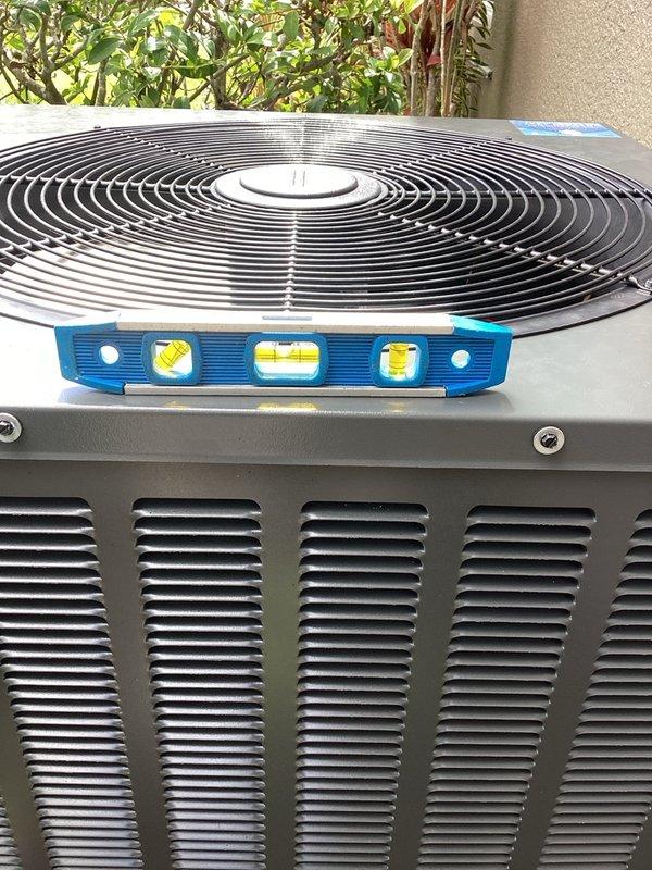 Responded to service call for noisy outdoor condensing unit. Upon arrival, verified unit placement and levelness using torpedo level, confirming unit was properly positioned on concrete pad. Inspected unit exterior, fan assembly, and mounting surface, finding equipment in good operating condition with no visible damage or deterioration that would contribute to noise complaints.