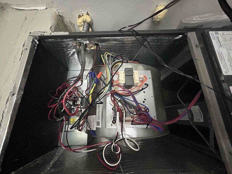 # PMA-RI MAINT 1 OF 4

Completed first quarterly preventive maintenance inspection on residential HVAC system. Performed comprehensive assessment of outdoor condensing unit, verified proper operation of compressor and condenser fan motor, and inspected refrigerant line connections for leaks or deterioration. Examined air handler electrical components and control board wiring connections, confirming all terminals were secure and properly seated. Documented equipment condition through photographic records showing exterior installation with associated water treatment equipment and interior electrical configuration of air handler control systems. All components found operating within normal parameters with no immediate service requirements identified.