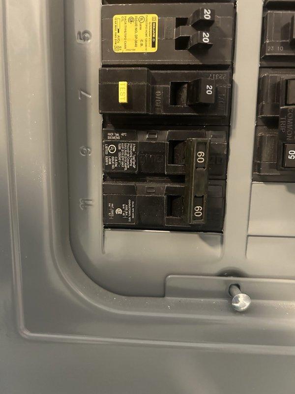 Sanibel, FL - Responded to a no cool complaint on a residential HVAC system located at a mobile home installation. Upon arrival, inspected the outdoor condensing unit and verified the electrical supply at the breaker panel. Documented the system configuration including the unit's position between structures, electrical connections, and surrounding installation conditions. The circuit breakers showed proper amperage ratings with no visible tripping or damage to the electrical panel components. Photographed the outdoor unit and electrical panel for service records to support diagnostic findings and future reference.