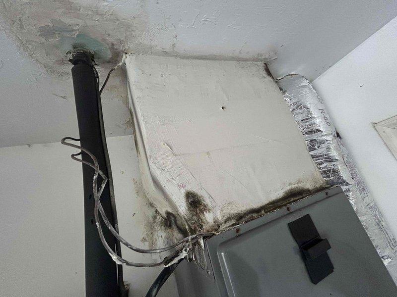 Cape Coral, FL - # Leaking Water and HVAC Inspection

Responded to service call regarding water leakage down wall and pest intrusion near air conditioning system. Upon arrival, conducted thorough inspection of HVAC air handler unit mounted in interior ceiling space. Investigation revealed significant water damage and staining on ceiling material surrounding the unit, with extensive brownish-gray discoloration and deterioration visible in upper corner areas. Identified dark mold and mildew growth along bottom seams of air handler casing where unit interfaces with ceiling, indicating ongoing moisture intrusion and condensation problems.

Documented multiple moisture-related issues including biological growth patterns, ceiling material degradation, and water staining throughout the installation area. Observed dirt accumulation and discoloration on equipment housing and adjacent wall surfaces. Flexible ductwork connection and electrical conduit routing were inspected for proper installation and potential l