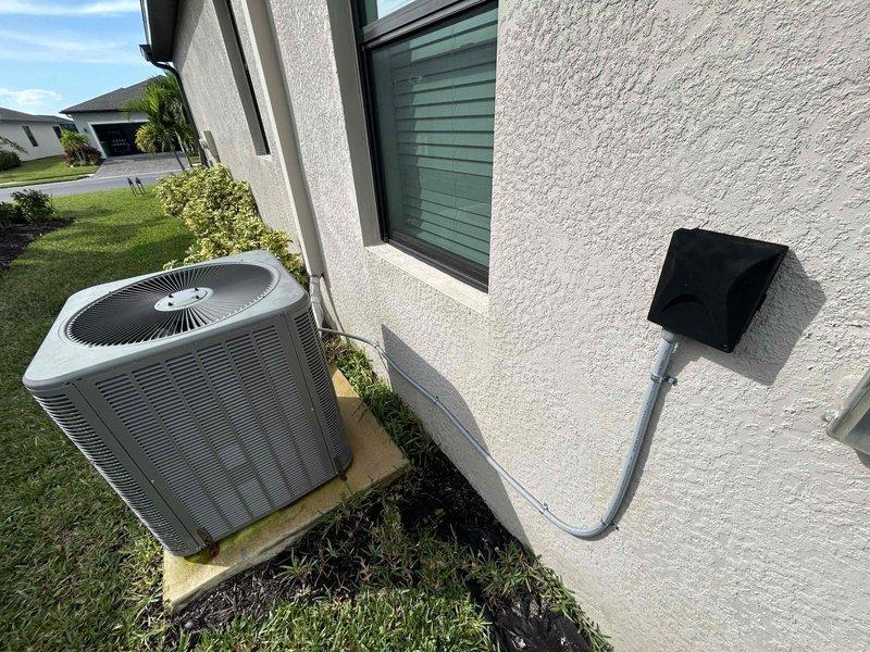 Port Charlotte, FL - Completed full system estimate for 2,198 square foot residence currently operating a Lennox unit with warranty-covered components on 8-10 week backorder. Evaluated property for 4-ton replacement system with customer preference for Ruud equipment, documented existing outdoor condenser unit placement on concrete pad with proper electrical disconnect, and assessed drainage configuration including PVC condensate line routing through landscaped area.