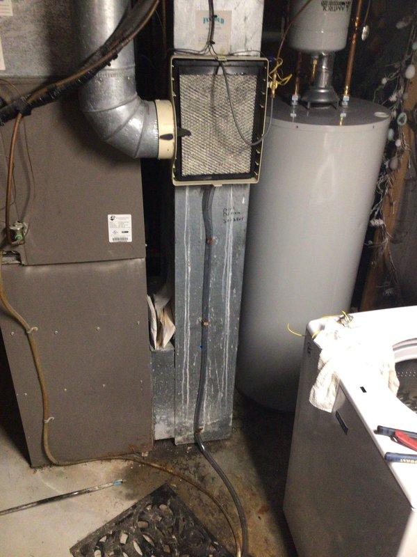 Diagnosed non-operational Aprilaire humidifier mounted on furnace system. Inspected mechanical room setup including air handler, filter housing, and associated ductwork. Visual assessment revealed system configuration and potential connection issues affecting humidifier functionality.