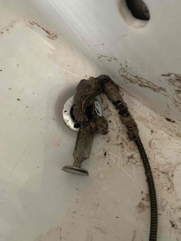 Responded to service call for dual plumbing issues in 1936 residence: bathroom sink drain clogged with significant mineral buildup and debris, and toilet with delayed flush cycling. Disassembled and thoroughly cleaned sink drain mechanism, removing accumulated grime and mineral deposits from stopper assembly. Serviced toilet tank by adjusting flush valve mechanism and cleaning mineral deposits from flapper and fill valve components to restore proper flush cycling functionality.