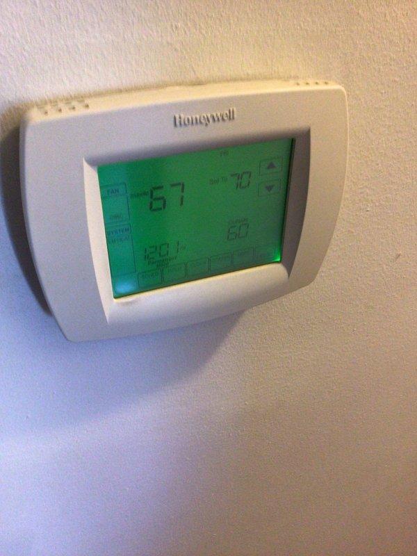 Performed scheduled heating tune-up on 16-year-old furnace located in basement. Inspected Honeywell digital thermostat (reading 67°F with 70°F setpoint) and verified proper operation. Opened unit to examine internal components including blower assembly, control board, and wiring connections - all found to be functioning normally with no issues detected.