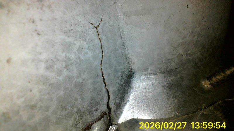 Responded to no-heat call where customer reported thermostat error code E298. Upon inspection, identified significant structural damage to concrete foundation near unit and discovered circular vent/drainage opening with substantial rust and moisture damage. Documented deterioration with photos for reference.