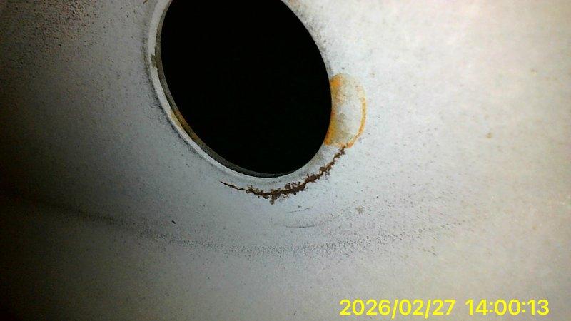 Responded to no-heat call where customer reported thermostat error code E298. Upon inspection, identified significant structural damage to concrete foundation near unit and discovered circular vent/drainage opening with substantial rust and moisture damage. Documented deterioration with photos for reference.