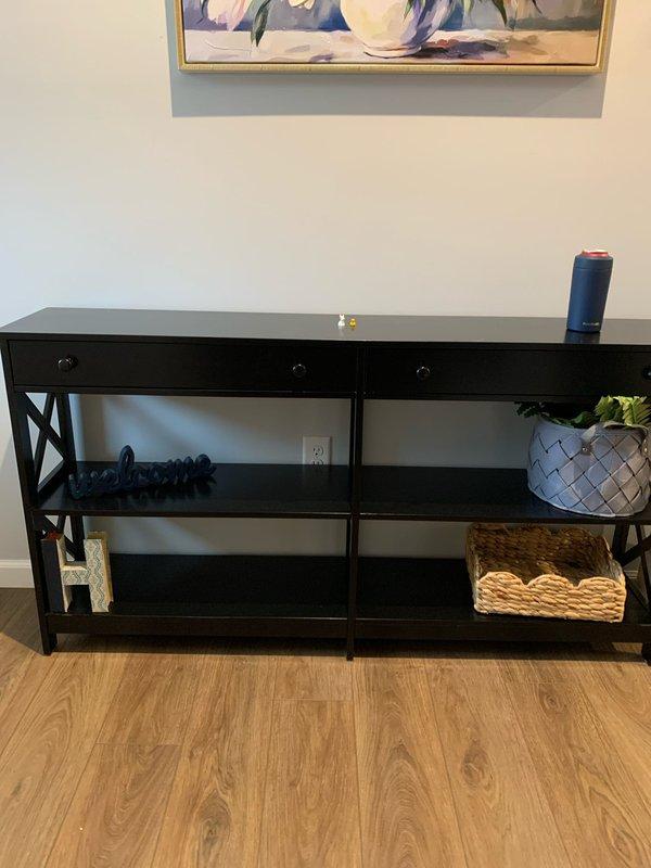 Performed electrical assessment for installation of hallway lighting on main floor and 4-5 receptacles in basement. Evaluated existing console table area with nearby electrical outlet on main floor and surveyed unfinished basement space with concrete flooring, exposed ductwork, and existing storage shelving to determine optimal receptacle placement for improved functionality.