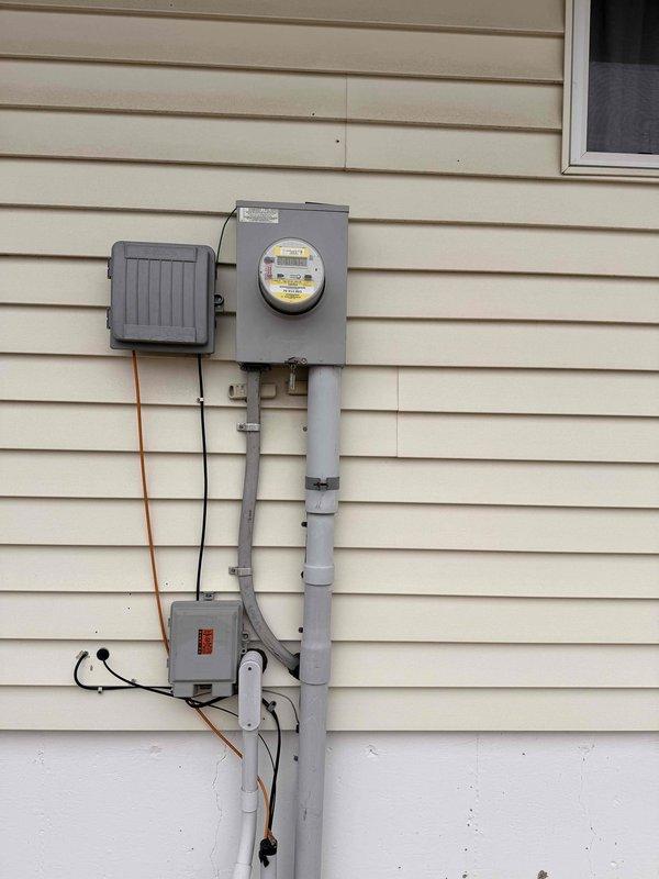 Performed comprehensive electrical panel inspection and service entrance assessment. Main distribution panel exhibited properly installed circuit breakers with standard color-coded wiring (red, white, black, and yellow conductors) in organized configuration. Exterior meter installation, conduit system, and grounding connections were examined and found to be in standard working condition with no visible deterioration or code violations.