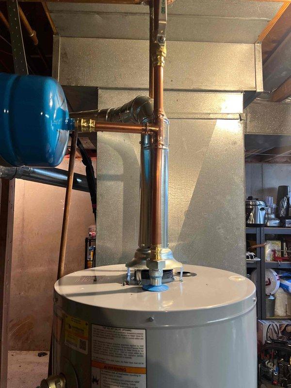 Successfully installed a new 40-gallon tall gas water heater in basement utility area with all required connections and fittings. Installed expansion tank and completed all copper pipe connections per local code requirements. Job was photographed for documentation and no permit was required by St. Charles County.