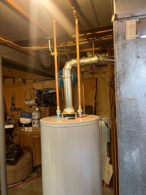Successfully installed a new 40-gallon tall gas water heater in basement utility area with all required connections and fittings. Installed expansion tank and completed all copper pipe connections per local code requirements. Job was photographed for documentation and no permit was required by St. Charles County.
