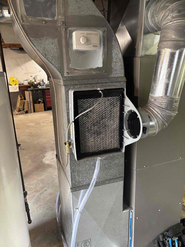 Inspected humidifier in basement where leaking was reported at hose connection. Examined copper plumbing assembly with brass valve and control components. Verified proper operation of HVAC system including filter condition and ductwork connections.