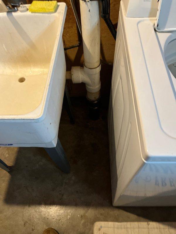 Responded to service call for utility sink drainage issue occurring during washing machine use in basement. Inspected PVC drainage system connecting both the sink and washing machine, identifying a partial clog in the shared drain line. Cleared obstruction using mechanical snake and verified proper drainage function with both appliances operating simultaneously.