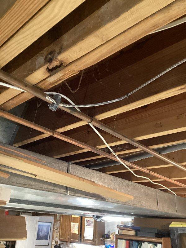 Conducted comprehensive electrical inspection of residential property, focusing on the main circuit breaker panel and exposed ceiling electrical runs. Identified several concerns including improper wire routing through ceiling joists, inadequate wire securing methods, and potential overloaded circuits in the main panel as evidenced by tripped breakers. Recommended professional remediation to address code compliance issues and safety concerns.