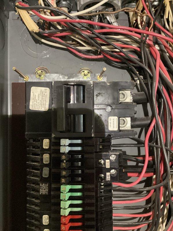 Conducted comprehensive inspection of residential electrical panel featuring multiple circuit breakers with standard color-coding (red, green, blue, gray). Examined wiring connections, verifying proper installation of hot (red/black) and neutral (white) conductors. Panel appears to be in functional condition with appropriate labeling on breakers, though some wire management improvements were recommended at the top section where bundling is dense.