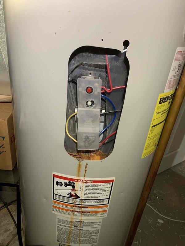 Conducted electrical inspection of residential water heater system, identifying corrosion at the control panel area and examining wiring connections to the thermostat module. Visual assessment revealed properly installed copper and metal piping but noted rust damage requiring attention at the lower section of the tank.