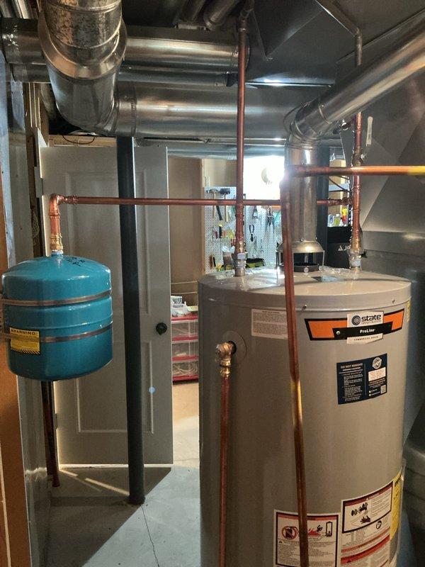 Successfully installed a new 75-gallon State ProLine gas water heater with proper venting and copper piping connections. Added blue expansion tank and applied identification sticker per permit requirements (#26PLU-04212). System tested and confirmed to be functioning correctly with no leaks.