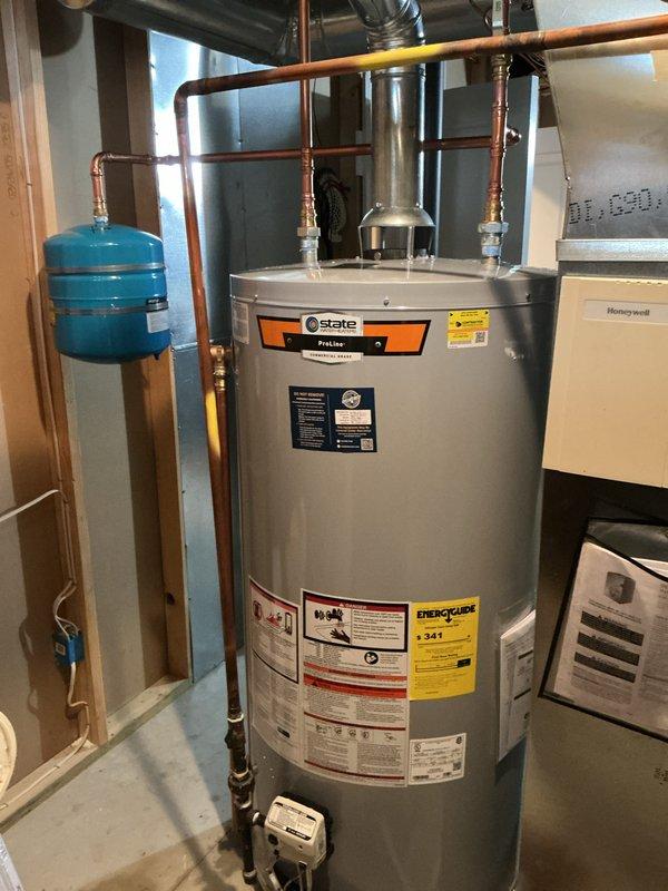Successfully installed a new 75-gallon State ProLine gas water heater with proper venting and copper piping connections. Added blue expansion tank and applied identification sticker per permit requirements (#26PLU-04212). System tested and confirmed to be functioning correctly with no leaks.