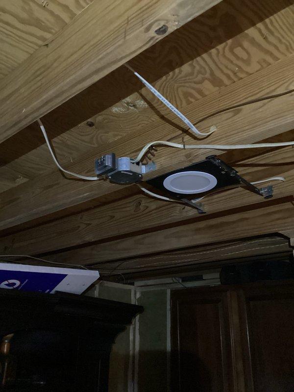 Conducted a complimentary electrical safety inspection for member, examining exposed recessed lighting fixtures in an unfinished ceiling area and testing electrical outlets throughout the home with a voltage tester. All receptacles tested showed proper wiring and grounding, with no immediate safety concerns identified in the visible electrical components.