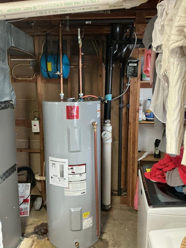 Installed 80-gallon electric tall water heater (model SEDT802ORTY122R) with expansion tank in utility area. Connected copper and PVC piping with appropriate valves and fittings, ensuring proper drainage system integration. Completed full installation with all necessary plumbing components for optimal operation.