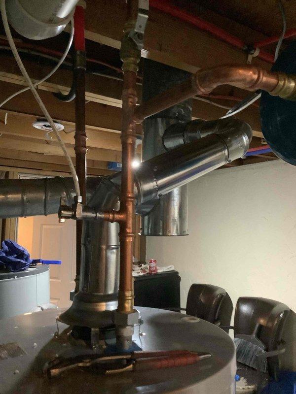 Successfully installed a 40-gallon gas tall water heater in basement utility area, including proper connection of copper supply lines and PVC drainage. Corrected existing flue system with new galvanized metal ductwork to ensure proper ventilation and code compliance. All connections were tested and system is functioning correctly.
