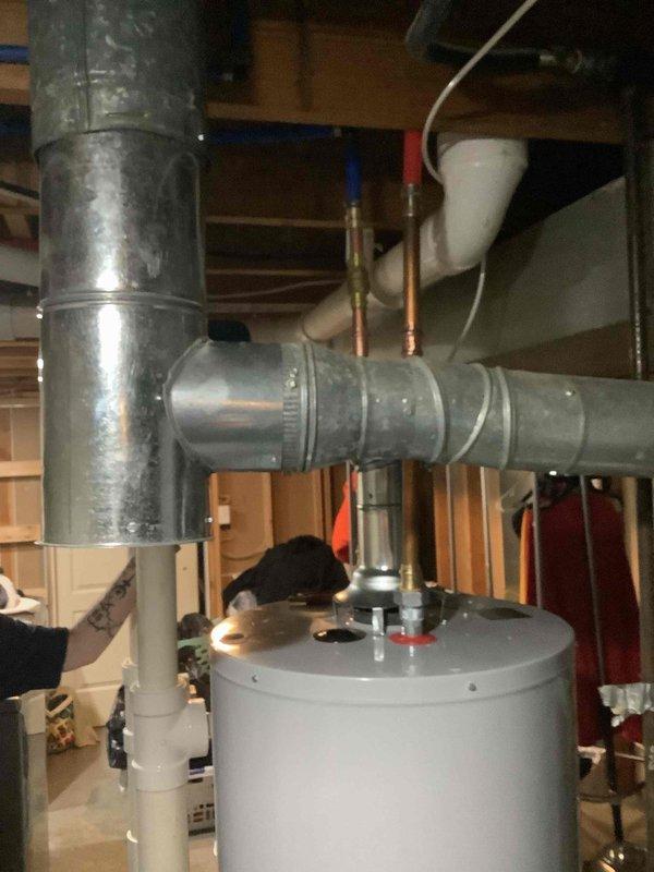 Successfully installed a 40-gallon gas tall water heater in basement utility area, including proper connection of copper supply lines and PVC drainage. Corrected existing flue system with new galvanized metal ductwork to ensure proper ventilation and code compliance. All connections were tested and system is functioning correctly.