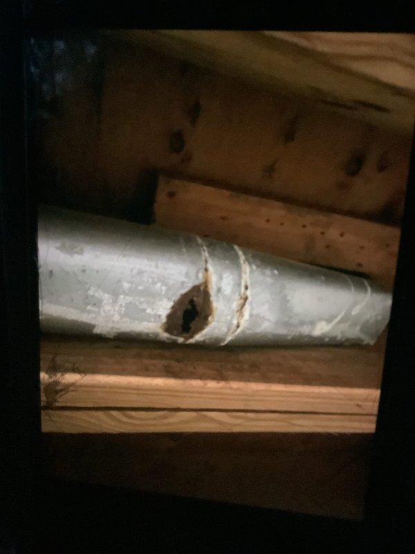 Performed scheduled heating tune-up on 12-year-old furnace located in basement. During inspection, discovered significant corrosion and a large puncture in the metal ductwork, indicating possible moisture damage and compromised system efficiency. Documented damage with photos and recommended duct repair/replacement to restore proper airflow and system performance.