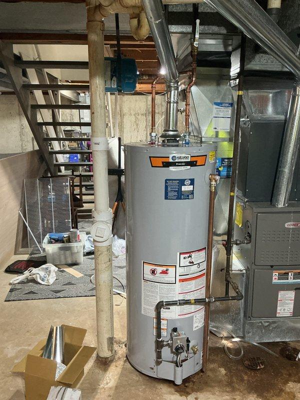 Successfully installed a 50-gallon tall gas water heater with proper permit (#26PLU-04316) and applied required plumbing ID sticker. System was properly connected to existing copper piping in the basement utility area, with all warning labels and specifications visible. Water treatment system was also installed, including two cylindrical filtration tanks and a brine tank with associated PVC piping and digital control unit.