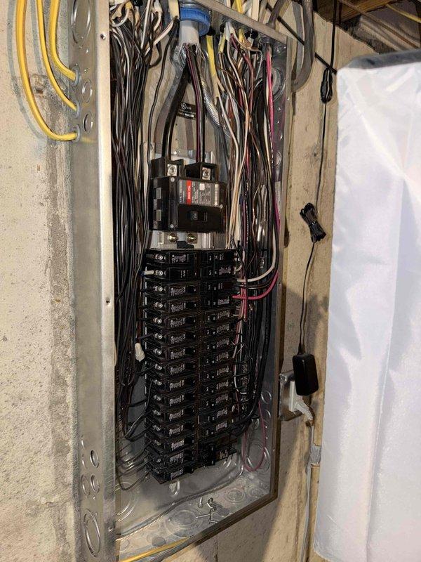 Conducted a free electrical inspection of the main service panel, examining the breaker arrangement, wiring connections, and overall installation integrity. Panel inspection revealed multiple circuits with appropriate wire routing through the upper joists, though noted dense wire bundling that may benefit from improved organization. All breakers appeared properly sized and installed with no signs of overheating or damage observed during the comprehensive safety evaluation.