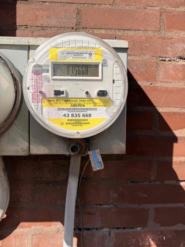 Performed complimentary inspection of residential electrical service entrance as part of membership promotion. Examined utility meter installation (Gridstream RF, Focus AXRe-SD) and surrounding electrical infrastructure. Visual inspection revealed standard Ameren meter setup with proper mounting on brick exterior wall, with associated service panel and conduits in serviceable condition.