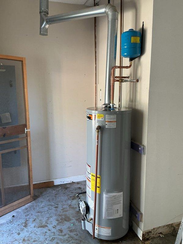 Successfully installed a new 40-gallon gas tall water heater in utility area, properly securing it with metal straps to the wall. Installed a blue expansion tank and connected all necessary copper pipes and galvanized metal ductwork, ensuring proper venting. All connections were tested and confirmed to be leak-free with system functioning as intended.