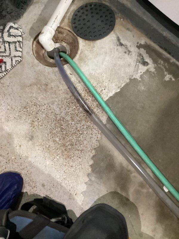 Inspected 7-month-old humidifier system in basement after customer reported mold in humidifier tube and possible standing water at duct connection. Identified water leakage around drain connection and documented moisture patterns on concrete floor. Verified mint-green condensate line routing and connection to drain system.