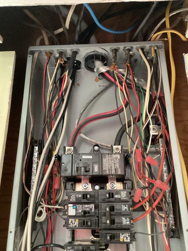 Conducted a comprehensive electrical panel inspection, examining circuit breakers, wiring connections, and load distribution. Documented the panel's internal components including multiple circuit breakers arranged in vertical columns with associated red, white, black, green, and yellow wiring. Verified proper organization of electrical conductors through metal conduits while noting the overall condition of the residential distribution system.