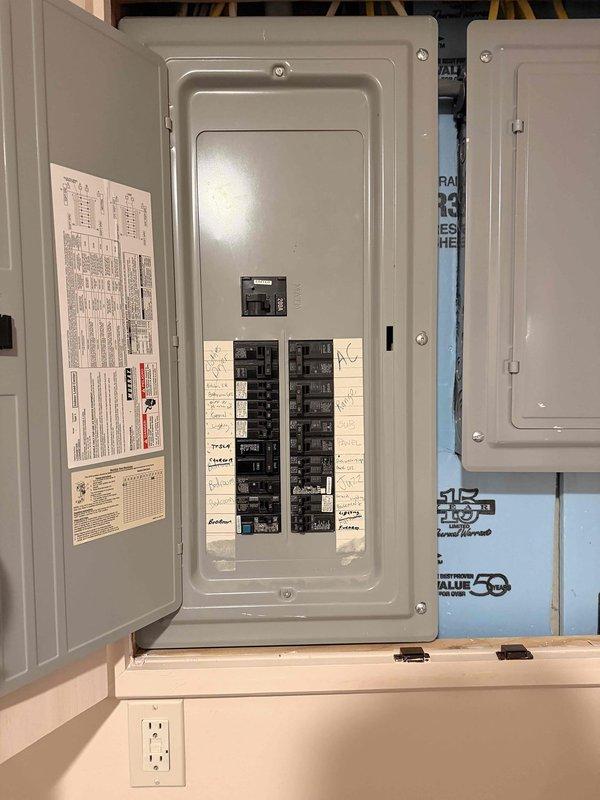 Completed complimentary electrical home audit, inspecting main service panel and exterior meter installation. Panel inspection revealed properly labeled circuit breakers with manufacturer documentation intact. Exterior evaluation showed standard service entrance configuration with digital meter and associated junction boxes mounted to vinyl siding. No immediate safety concerns identified.