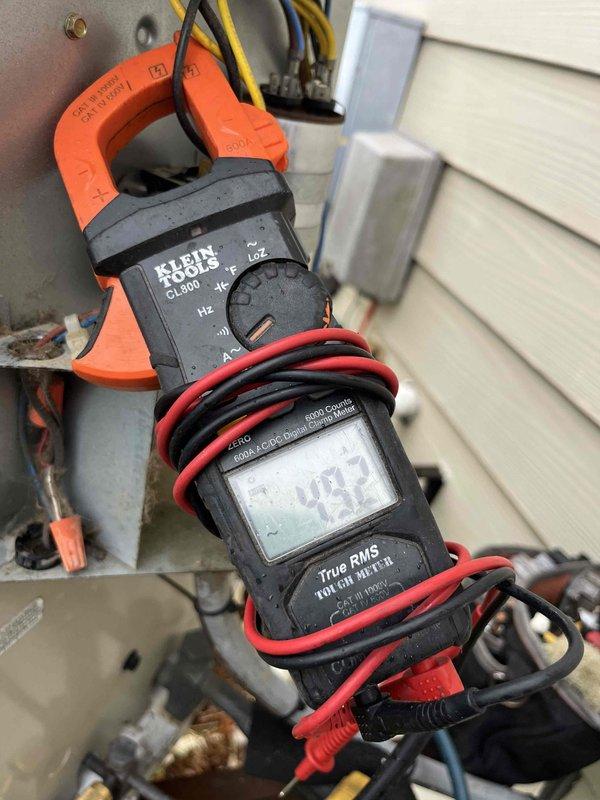 Performed comprehensive cooling maintenance on two AC systems (one <5 years old, one >15 years old). Conducted amperage testing using Klein CL800 clamp meter, recording 49.2A during operation. Inspected older condenser unit showing normal weathering and slight rust formation on upper section; both units were operational upon completion of service.