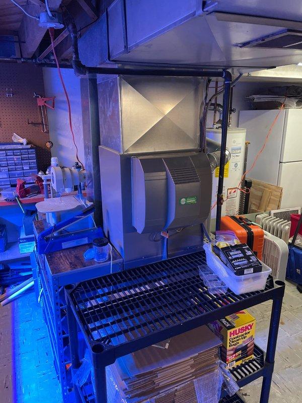 Performed diagnostic assessment on 9-year-old AC system installed in 2022, addressing customer complaint of reduced airflow despite cool air output. Inspected Emerson digital thermostat (functioning properly at 74°F with 70°F setpoint) and examined air handler unit with connected ductwork in utility area. Determined airflow restriction was caused by partially blocked evaporator coil; cleaned coil and verified improved system performance with proper airflow restored.