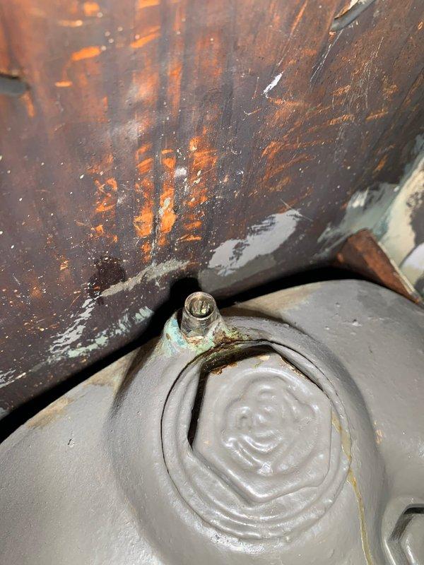 Responded to service call for leaking radiator in living room. Inspection revealed corrosion at valve connection with visible greenish patina formation. Noted improper wall mounting of adjacent utility connection with gap allowing moisture intrusion, contributing to system deterioration.