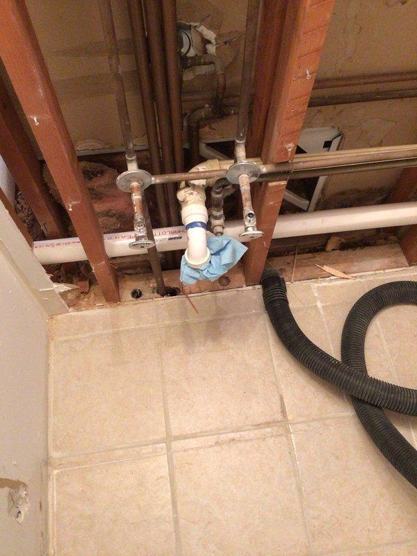 Completed installation of PVC plumbing infrastructure for first floor laundry relocation per permit #26PLU-04091. Work included removal of bathroom fixtures and opening walls to install 2" Schedule 40 PVC drain lines from new laundry location to main stack, along with necessary water supply lines. Additionally installed dryer vent flue through dining room wall with custom soffit and exterior wall penetration.