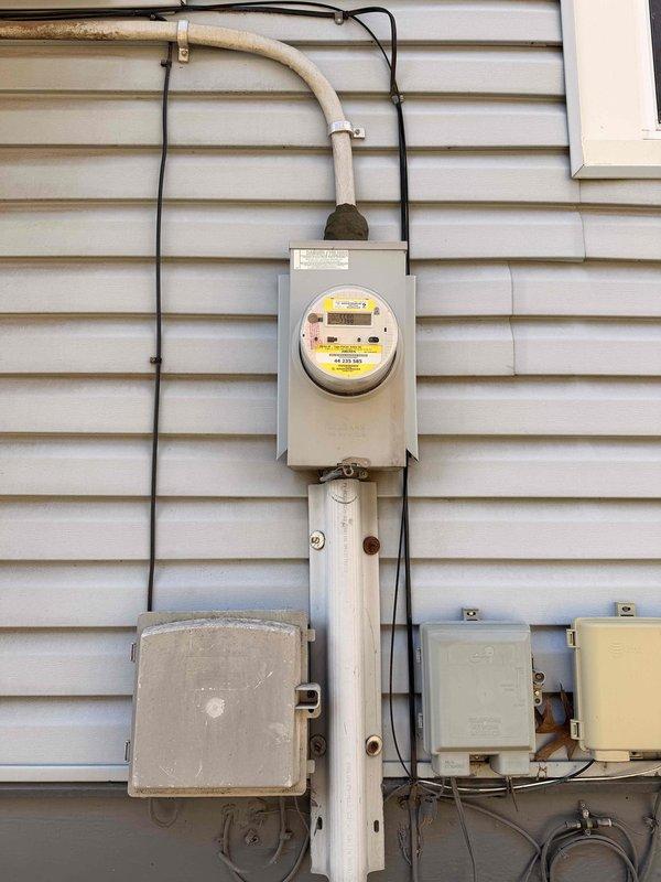 Completed home electrical audit with focus on exterior service components. Inspected main electrical meter installation, including digital meter, conduit integrity, and multiple junction boxes mounted on the house exterior. Documented current condition of residential power distribution system with photographic evidence for assessment purposes.